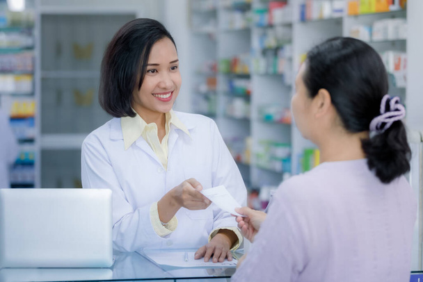 femme médecin main donnant prescription au patient en pharmacie magasin Thaïlande  - Photo, image