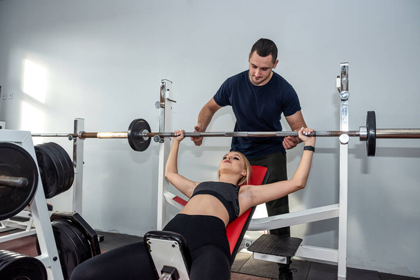 happy healthy friendly male trainer conducts personal training with beautiful client. The concept of physical training in the gym on personal training - Foto, Imagem