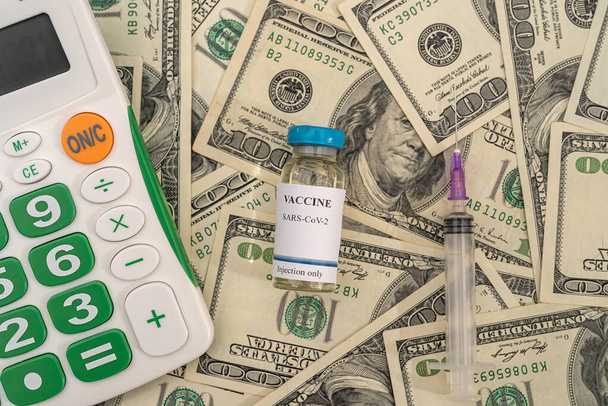I flaconi di vaccino con siringhe giacciono sulle banconote da un dollaro. Concetto di vaccinazione - Foto, immagini