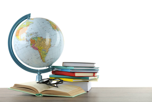 Globe, books and eyeglasses on wooden table against white background. Geography lesson - Fotoğraf, Görsel