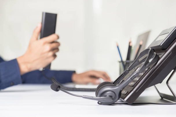 De medewerker van het callcenter wijst naar het knopnummer op de telefoonbalie, de communicatieondersteuning, het callcenter en de helpdesk van de klantenservice. voor (call center) concept - Foto, afbeelding