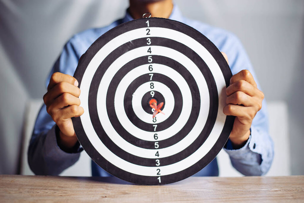 Businessman holding a darts aiming at the target center business goal concept - business targeting, aiming, focus concept,metaphor to target marketing or target arrow to business successconcept. - Foto, imagen