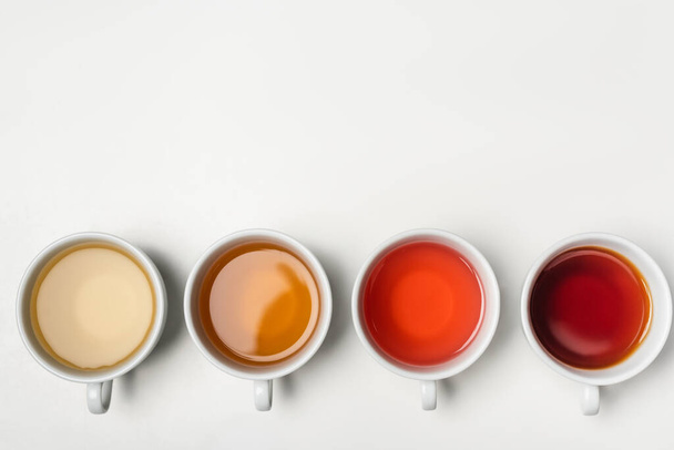 Draufsicht auf Tassen Tee auf weißem Hintergrund mit Kopierraum  - Foto, Bild