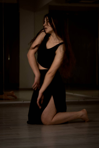 νεαρή γυναίκα χορεύτρια. σε φόντο τοίχο. - Φωτογραφία, εικόνα