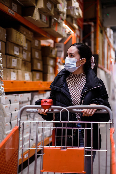 nuori nainen huonekalukaupassa pandemian turvallisuussääntöjen kanssa - Valokuva, kuva