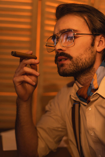 young man with mustache and eyeglasses smoking cigar  - Φωτογραφία, εικόνα
