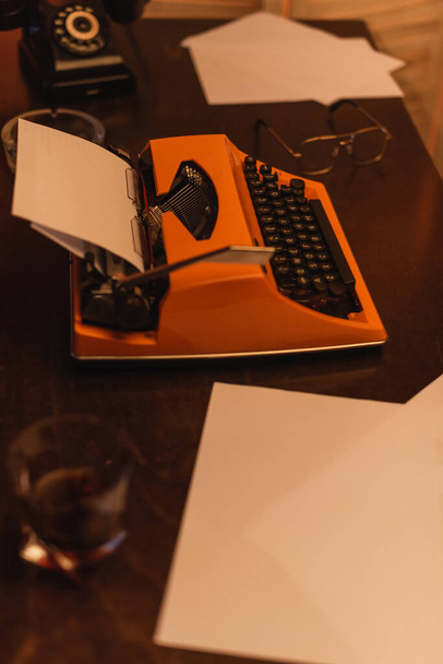 vista ad alto angolo della macchina da scrivere vicino a carte e vetro di whisky  - Foto, immagini