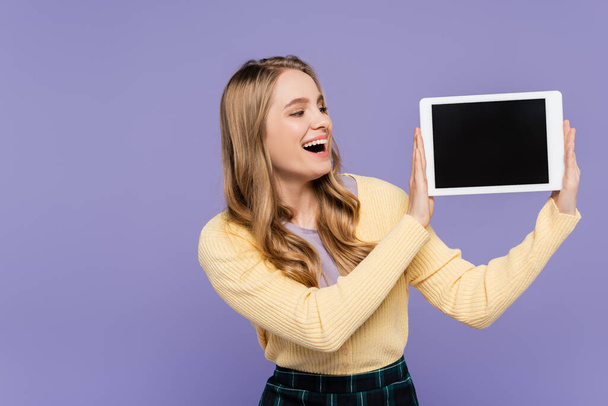 amazed young woman holding digital tablet with blank screen isolated on purple - Fotografie, Obrázek