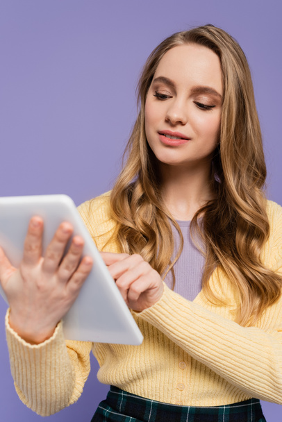 молода жінка використовує цифровий планшет ізольовано на фіолетовому
 - Фото, зображення
