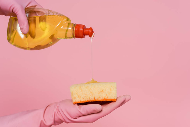 partial view of woman pouring detergent on sponge isolated on pink  - Fotografie, Obrázek