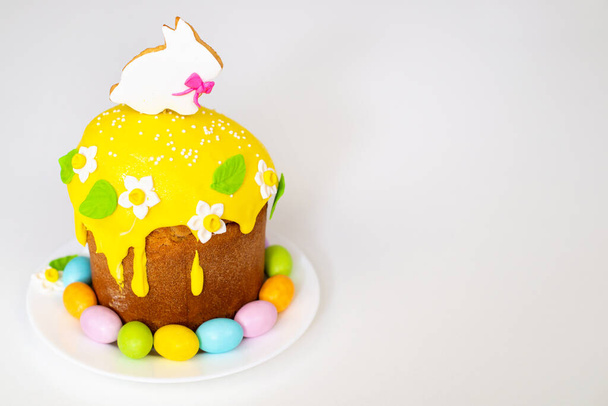 Easter cake with a rabbit and painted eggs on a white background. Religious holiday - Фото, изображение