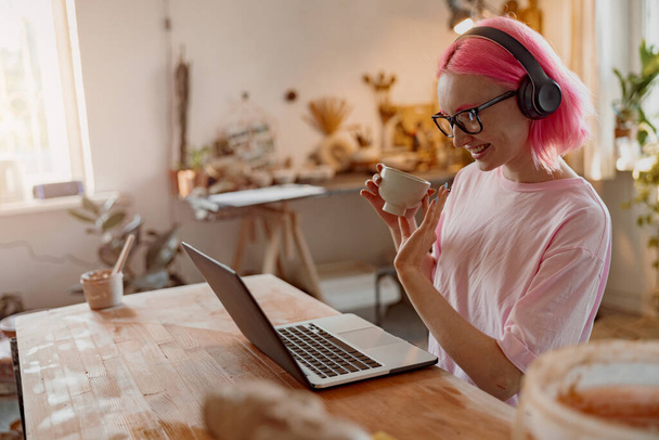 Fiatal kézműves nő laptop számítógép a művészeti stúdióban - Fotó, kép