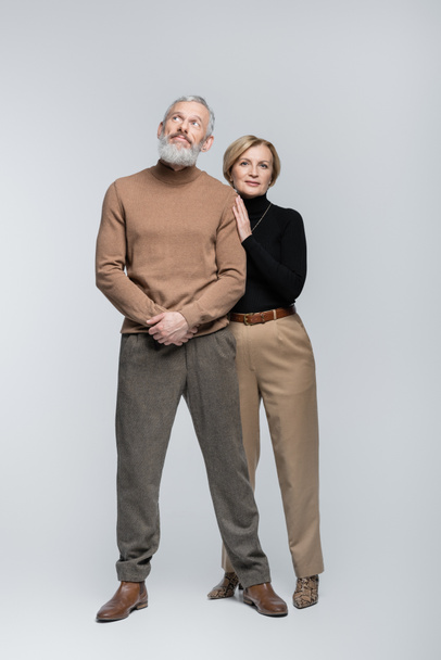 Full length of stylish mature couple posing on grey background  - Фото, зображення