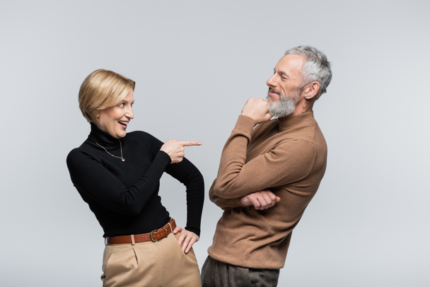 Positive reife Frau zeigt auf stilvollen Ehemann isoliert auf grau  - Foto, Bild