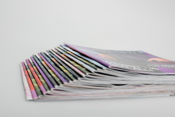 pila de revistas borrosas sobre fondo gris - Foto, Imagen