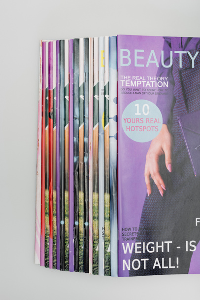 top view of beauty magazines stacked isolated on grey - Photo, Image