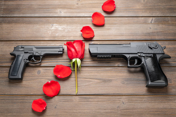 Пелюстки троянд і пістолет на борту. Концепція миру
. - Фото, зображення
