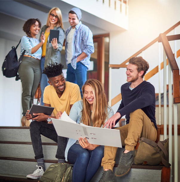 Vamos a salir adelante juntos. Fotografía de un grupo de estudiantes universitarios trabajando juntos en la escalera del campus. - Foto, Imagen