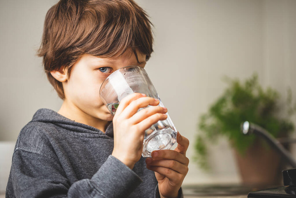 Criança bebendo água potável em casa  - Foto, Imagem
