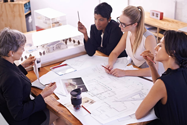Meeting of the minds. A group of female architects working together on a project at a conference table. - Foto, imagen