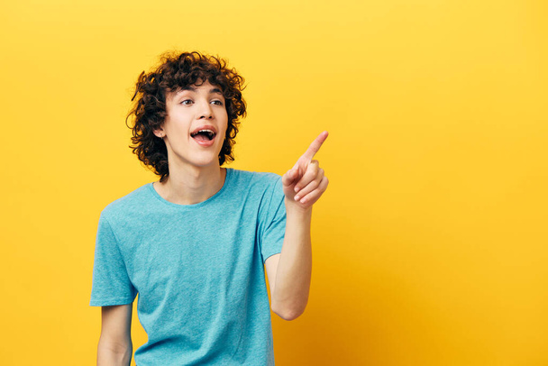happy guy with curly hair shows thumb up yellow background - Photo, Image