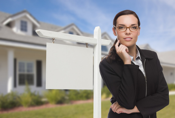Женщина перед домом и знак "Недвижимость"
 - Фото, изображение