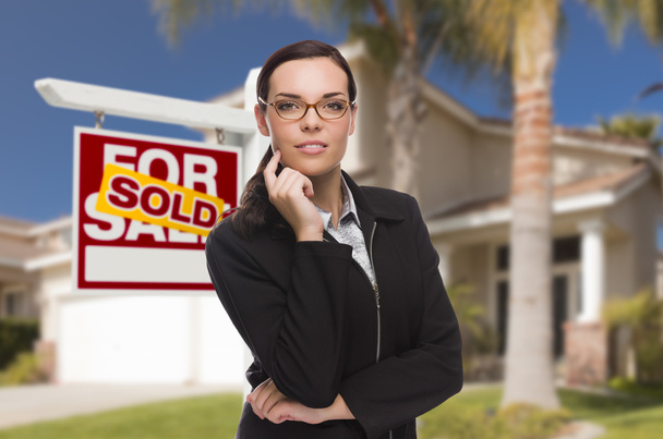 Mujer de raza mixta en frente de la casa y vendida signo
 - Foto, imagen