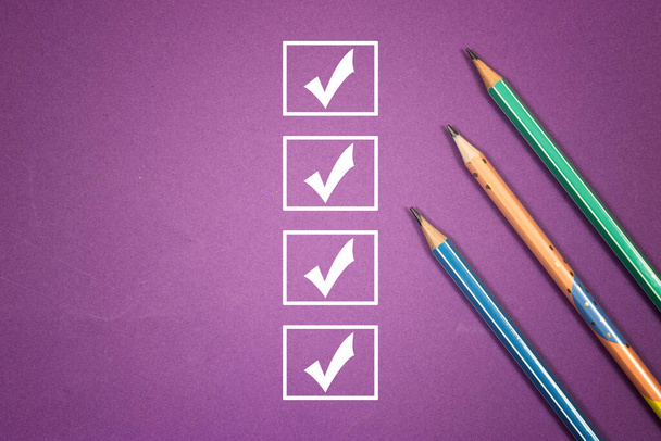 merkintä tarkistuslistan ruutuun. Checklist-konsepti, kolme kynää, joissa on kopiointitilaa violetilla taustalla - Valokuva, kuva