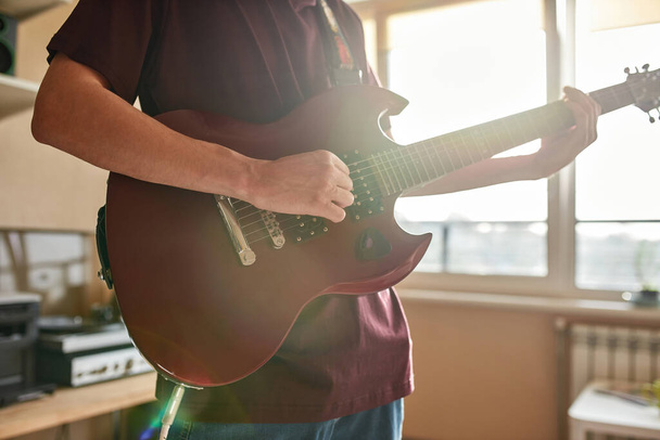 Partial of man playing notes on electric guitar - Photo, image