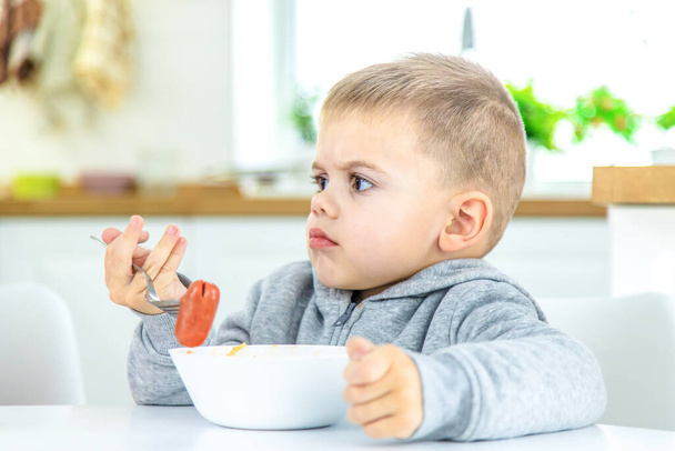 i bambini in cucina a tavola mangiano la pasta. focus selettivo - Foto, immagini