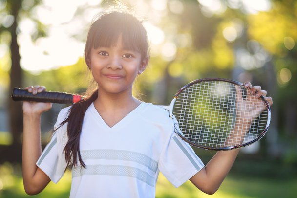 Piccola ragazza asiatica che tiene una racchetta badminton
 - Foto, immagini