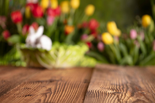 Pâques. Décorations de Pâques sur la table rustique en bois. Lapin de Pâques, oeufs de Pâques dans le panier. Bouquets de fleurs de printemps.  - Photo, image