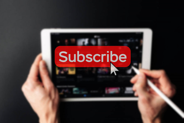 Subscription plan. Red online video subscribe button. Internet service on laptop digital tablet blured technology background. Visual contents concept. Social networking service. - Photo, Image