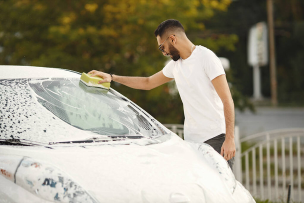 Indian man washing his white transportation on car wash - 写真・画像
