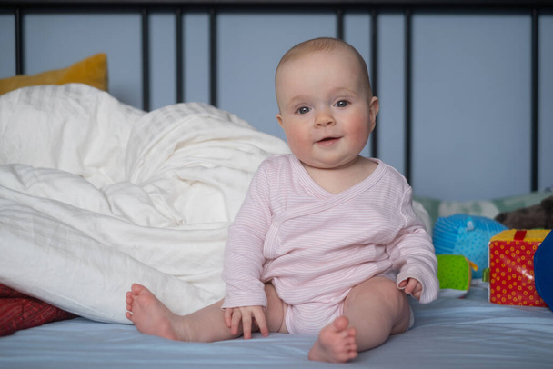 Мила щаслива біла 6 місяців дівчинка в підгузник лежить і грає - Фото, зображення