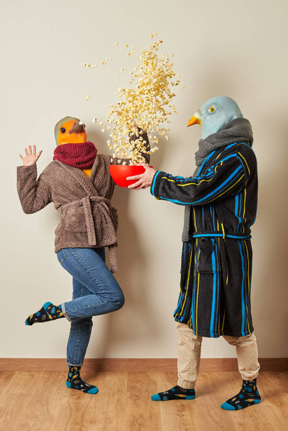 Als Vögel verkleidetes Paar hat eine Überraschung für Popcorn in der Luft - Foto, Bild