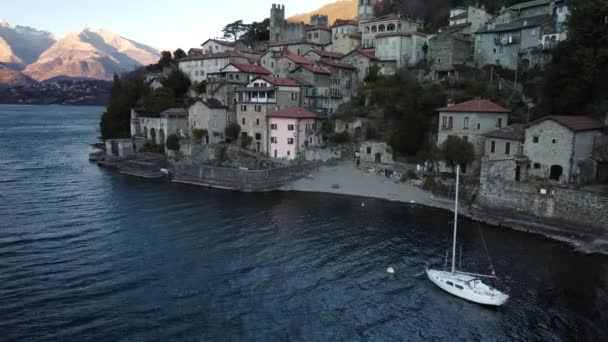 AERIAL VIEW in Verbindung setzen. Kleines Dorf am Comer See neben einem Yachthafen mit festgemachten Booten - Reiseziel - Dervio, Lombardei, Italien - Filmmaterial, Video