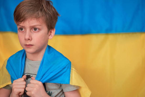 Boy holding in hands Ukrainian yellow-blue flag. Kids support Ukraine by showing heart - Photo, Image