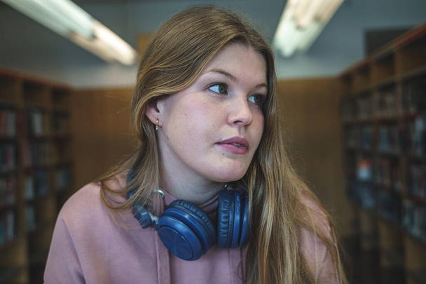 fiatal női hallgató a könyvtárban - Fotó, kép