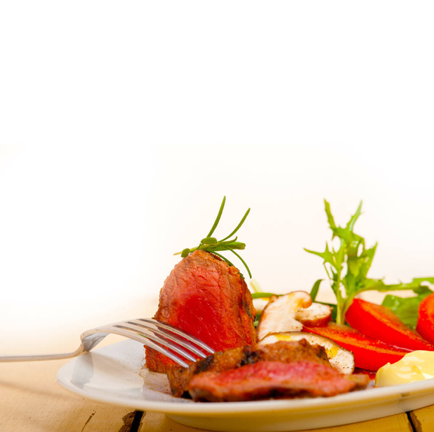 牛フィレ・ミグノンに新鮮な野菜を並べて焼きトマトとアルグラサラダ - 写真・画像