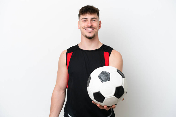 Jovem caucasiano bonito homem isolado no fundo branco com bola de futebol - Foto, Imagem