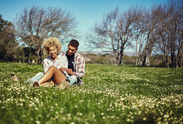 This is our favorite spot. Shot of a young couple spending quality time together at the park. - Photo, Image