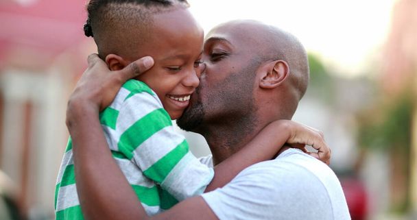 Father and son love care and affection. African dad cuddling with child son - Foto, imagen
