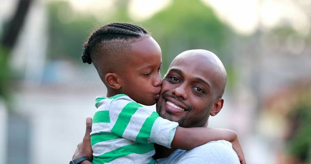 Батько і син люблять і люблять. Африканська етнічна належність. Тато і дитина обіймаються. - Фото, зображення