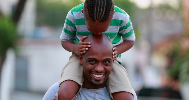 Afrikai apa-fia kapcsolat. Gyerek csók apa kopasz fej, gyermek tetején apa vállán - Fotó, kép