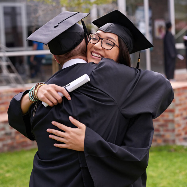 Ζει μεγάλες στιγμές. Φωτογραφία δύο μαθητών που αγκαλιάζονται την ημέρα της αποφοίτησης. - Φωτογραφία, εικόνα