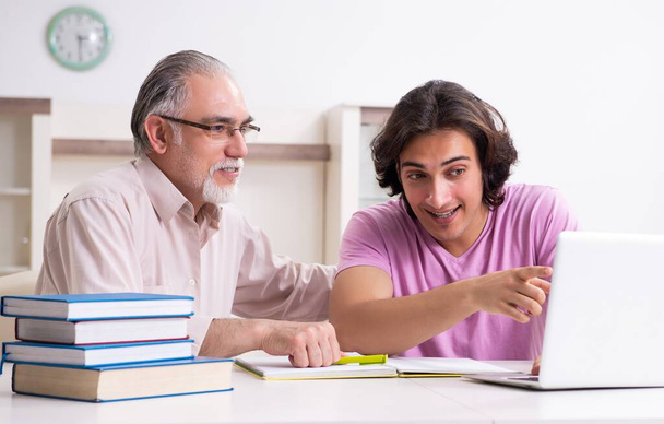 alter Vater hilft seinem Sohn bei der Prüfungsvorbereitung - Foto, Bild