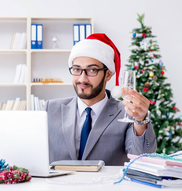 Fiatal üzletember ünnepli a karácsonyt az irodában - Fotó, kép