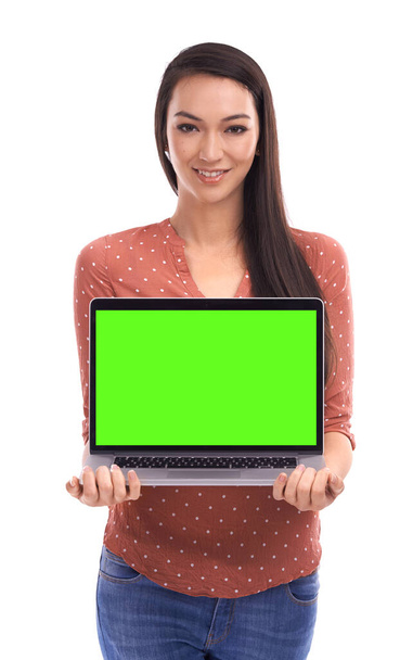 Dies ist Ihre Online-Präsenz. Porträt einer schönen jungen Frau, die lächelt und einen Laptop vor weißem Hintergrund zeigt. - Foto, Bild