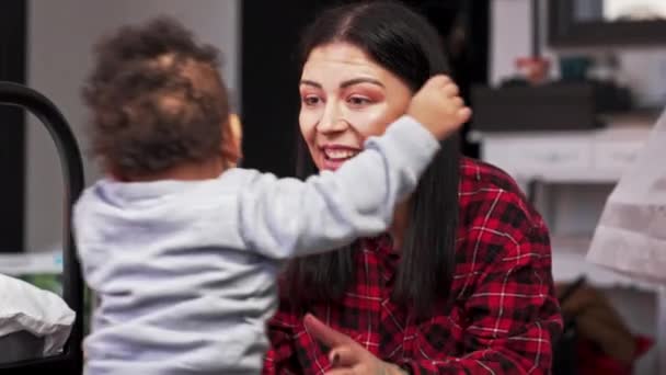 Радостная кавказская брюнетка мать поднимает своего очаровательного ребенка смешанной расы. - Кадры, видео